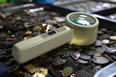 Coin collector examining a collection with a loupe